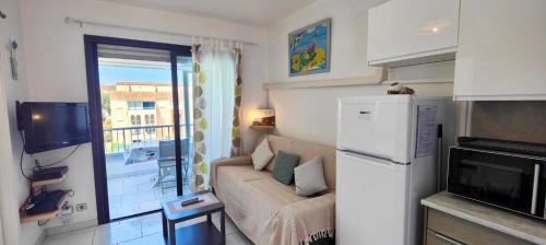 - un petit salon avec un canapé et une fenêtre dans l'établissement Apartment with pool near the city center, à Fréjus