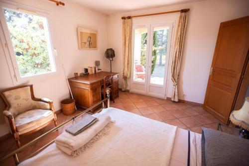 une chambre avec un lit, une chaise et un bureau dans l'établissement Villa Massada, à Saint-Maximin-la-Sainte-Baume