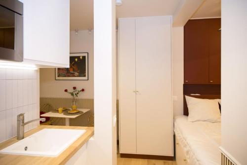 une petite salle de bain avec un lavabo et un lit dans l'établissement Studio fonctionnel et moderne place Clichy - 2P, à Paris
