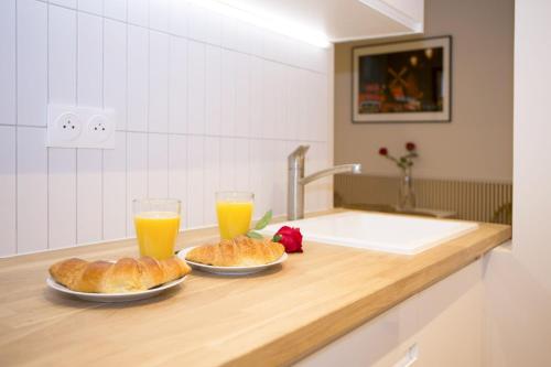 2 assiettes de croissants et 2 verres de jus d'orange dans l'établissement Studio fonctionnel et moderne place Clichy - 2P, à Paris