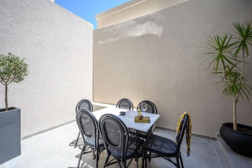 a table and chairs on a patio with plants at Montre Fine Living in Agios Nikolaos