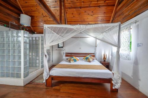 a bedroom with a bed with a canopy at A casa di Giorgia lodge Nosy be Andilana in Nosy Be