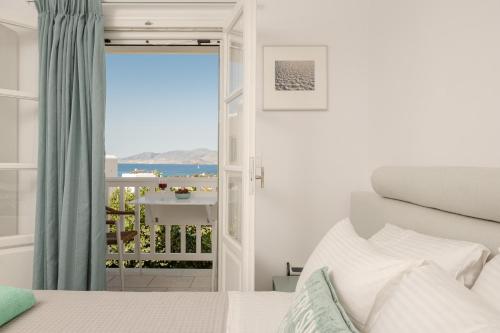a bedroom with a bed and a view of the ocean at Caruana Living in Agia Anna Naxos