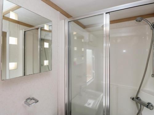 a bathroom with a glass shower and a sink at Willow in Denny