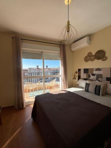 a bedroom with a bed and a large window at Apartamentos Eras Centro in Malpartida de Plasencia