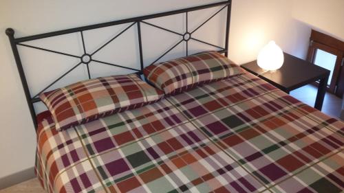 a bedroom with a bed and a lamp on a table at Archi e Colonne in Verbania