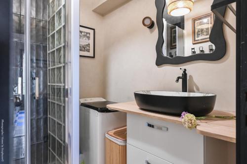 La salle de bains est pourvue d'un lavabo noir et d'une douche. dans l'établissement Balcon filant, calme & parking, à Marseille