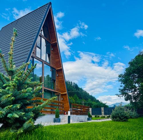 a wooden house with a gambrel roof at Hidden Cabin in Brezoi