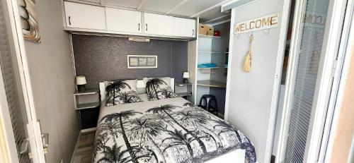 - une chambre avec un lit orné de palmiers dans l'établissement Tropica Nîmes Chalet 2 chambres confort climatisé, à Nîmes