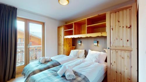 a bedroom with a large bed with towels on it at Pracondu 2 302 - OUTDOOR & FUN apartment 4 pers in Nendaz