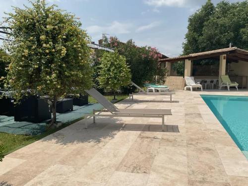 a pool with a bench next to a house at Villa charmante à Villecroze avec piscine privée in Villecroze