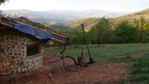 a stone building in a field with mountains in the background at gîte de l'aigle in Aouste-sur-Sye