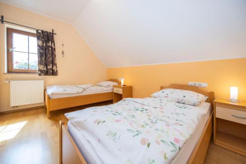 une chambre avec deux lits et une fenêtre dans l'établissement Tourist Farm Rajšp, à Benedikt v Slovenskih Goricah