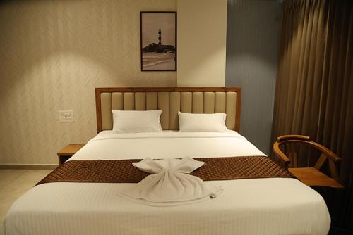 a bedroom with a large bed with a robe on it at Palm Breeze Beach Resort in Mangalore