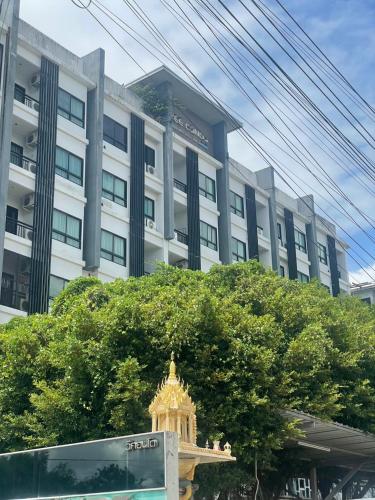 a large white building with a tree in front of it at Vee Condo 502 in Mae Sot