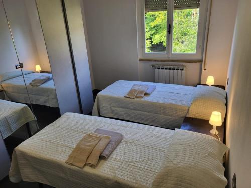 a room with two beds with towels on them at DOMUS LuNi Cinque Terre, wifi ,aria condizionata in Castelnuovo Magra