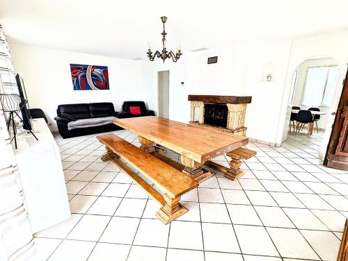 un salon avec une table et une cheminée dans l'établissement Villa Le Jardin des Délices - de 2 à 8 personnes avec Piscine, à Raissac-dʼAude