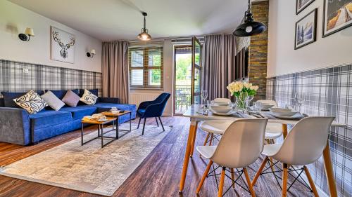 a living room with a blue couch and a table at Karpacz Residence, Sun & Snow in Karpacz