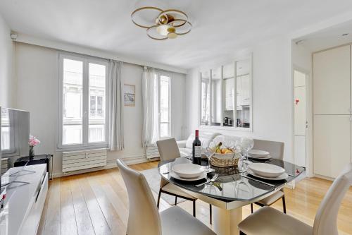 une salle à manger avec une table et des chaises en verre dans l'établissement Suite Charlie Cardinet - Opulence au cœur de Paris, à Paris