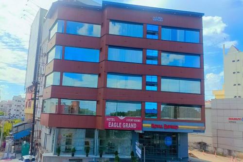 a tall red building with a sign on it at Hotel Eagle Grand Airport Zone in Shamshabad