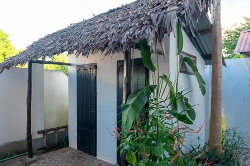 a small white house with a thatched roof at A casa di Giorgia lodge Nosy be Andilana in Nosy Be