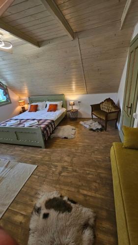 a bedroom with a large bed and a wooden ceiling at Casa cu Moara in Râșca