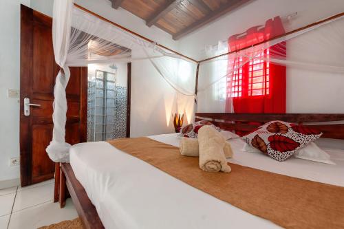 a bedroom with a large white bed with pillows at A casa di Giorgia lodge Nosy be Andilana in Nosy Be
