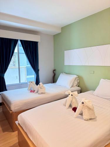a room with two beds with stuffed animals on them at Nantra de Comfort in Bangkok