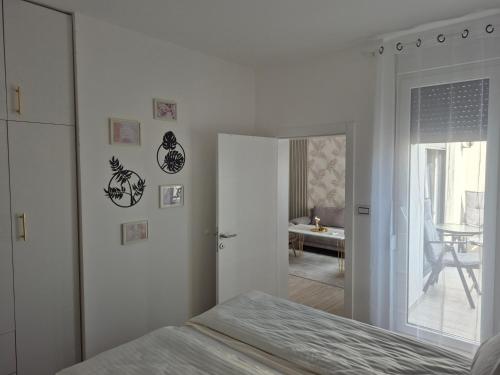 Un dormitorio blanco con una cama y un espejo. en Gold LUX, en Novi Sad
