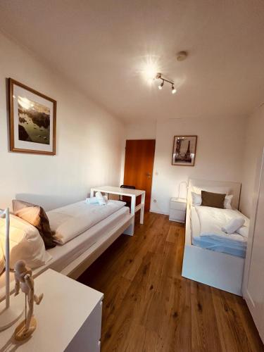 a room with two beds and a table in it at Osnabrücker Strasse Wooon 10 Einzelbetten I 5-Zimmer I TV I Bad NEU I Premiumbettwäsche in Ibbenbüren