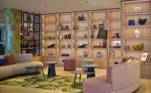 a lobby with couches and tables and shelves with vases at Hilton Garden Inn Leiden in Leiden