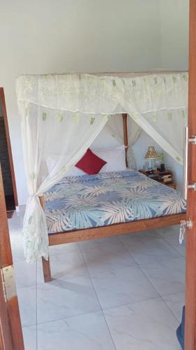 a bed with a canopy in a room at Cegeng Lestari Guesthouse in Sidemen