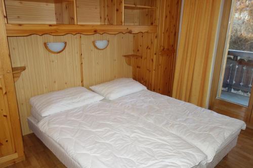 Letto bianco in camera di legno con finestra di Pracondu 1 405 - OUTDOOR & FUN apartment 6 pers a Nendaz