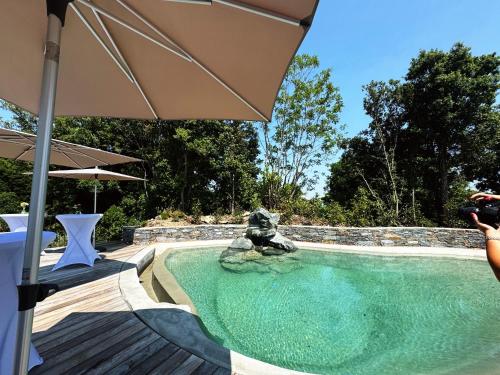 une personne prenant une photo d'une statue dans une piscine dans l'établissement Domaine Santa Margherita, à Castellare-di-Casinca