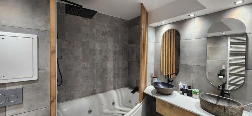 un bagno con un lavandino, una vasca e uno specchio di Duplex balneo cosy proche CDG et Stade de France a La Courneuve