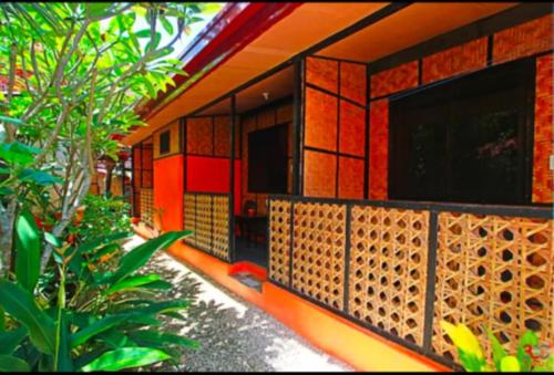 a red building with a fence in front of it at Adriana's Place Tropical Guesthouse in Panglao