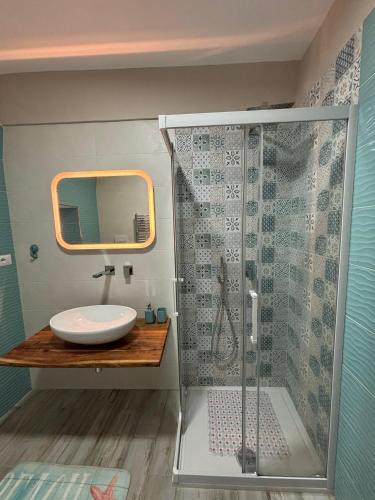 a bathroom with a shower with a sink and a mirror at Appartamento Dimora Danto in Manfredonia