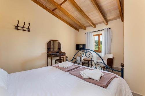 a bedroom with a white bed and a tv at Finca es Rafal, Agroturisme in Montuiri
