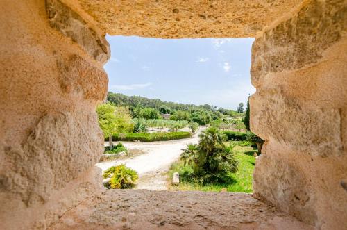a view of a dirt road through a stone window at Finca es Rafal, Agroturisme in Montuiri