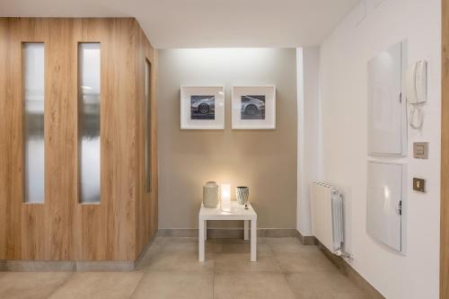 un couloir avec une table blanche et une porte dans l'établissement Family Catedral Centro, à Grenade