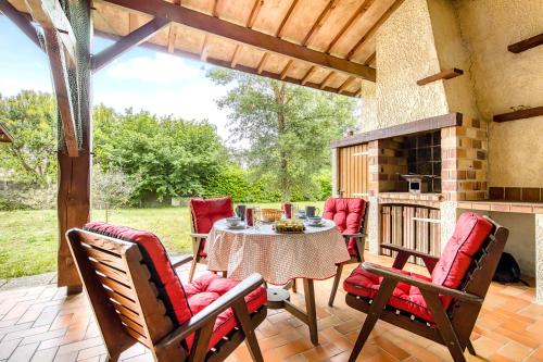 un patio avec une table, des chaises et une cheminée dans l'établissement Maison de vacances Valériane, à Lège-Cap-Ferret