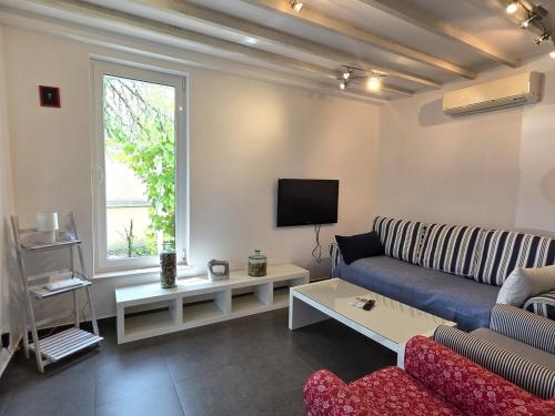 a living room with a couch and a tv at Holiday House Hlad in Baška