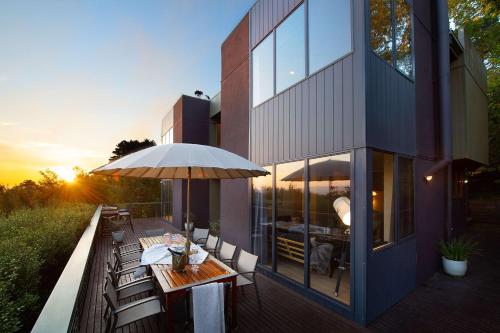 a patio with a table and an umbrella at Daybreaker Daylesford in Daylesford