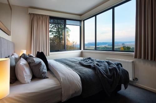 a bedroom with a bed and large windows at Daybreaker Daylesford in Daylesford
