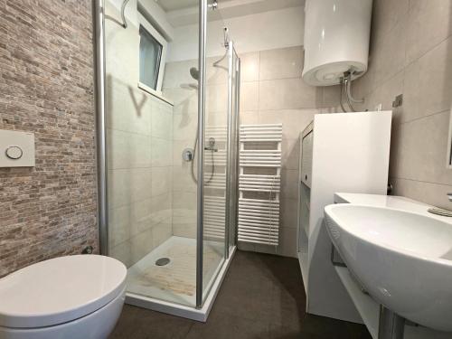 a bathroom with a shower and a toilet and a sink at Holiday House Hlad in Baška