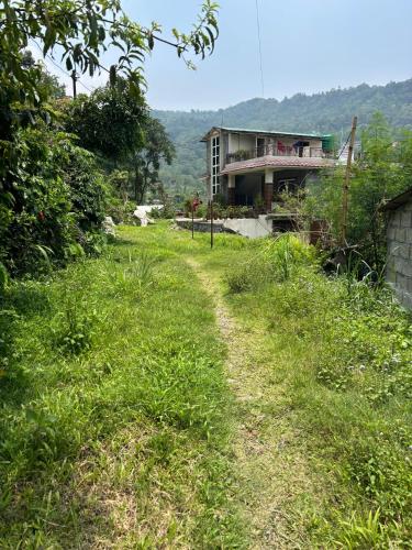 a house on the side of a grassy hill at Unmani Yoga Retreat Pokhara in Pokhara