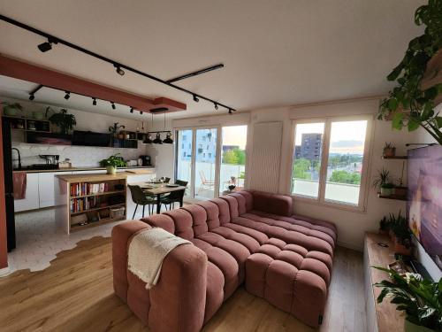 Il comprend un salon avec un canapé et une cuisine. dans l'établissement Duplex balneo cosy proche CDG et Stade de France, à La Courneuve