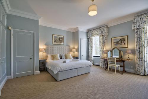 a bedroom with a bed and a desk and a chair at Abbey House by Group Retreats in Saffron Walden