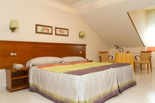 ein Schlafzimmer mit einem großen Bett in einem Zimmer in der Unterkunft Hostal Siete Picos in El Espinar