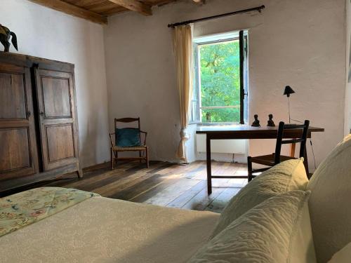 ein Schlafzimmer mit Bett, Schreibtisch und Fenster in der Unterkunft The Guardians Cottage, Chateau Mas de Pradie in Foissac